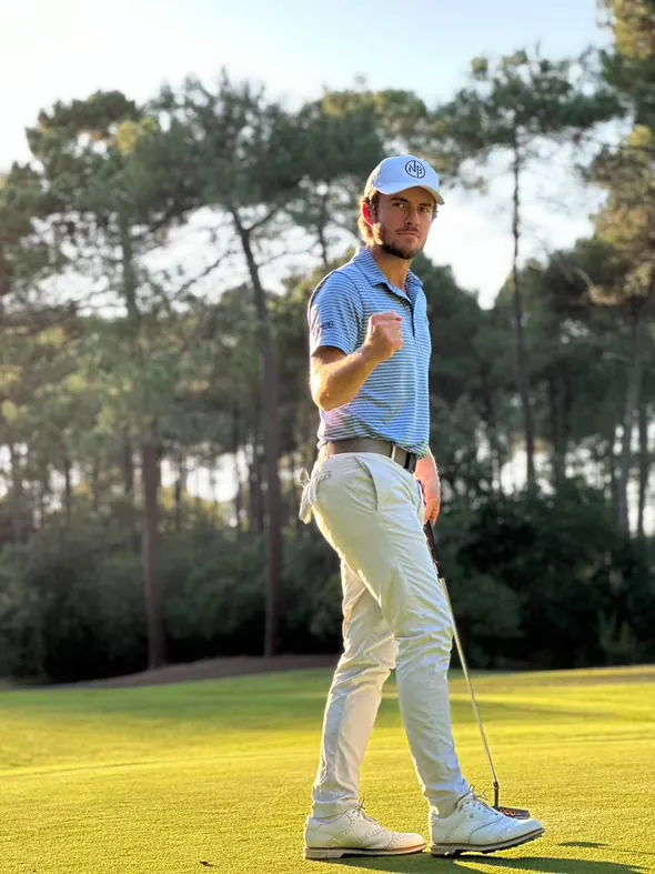 Nils Bouchilloux sur un green, casquette au monogramme NB, putter à la main, poing serré après un putt rentré